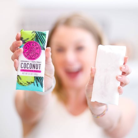 Woman smiles and holds Pitaya coconut smoothie pack