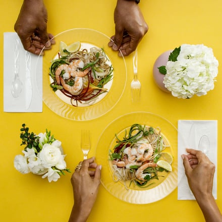 Hands holding Chinet plates with food